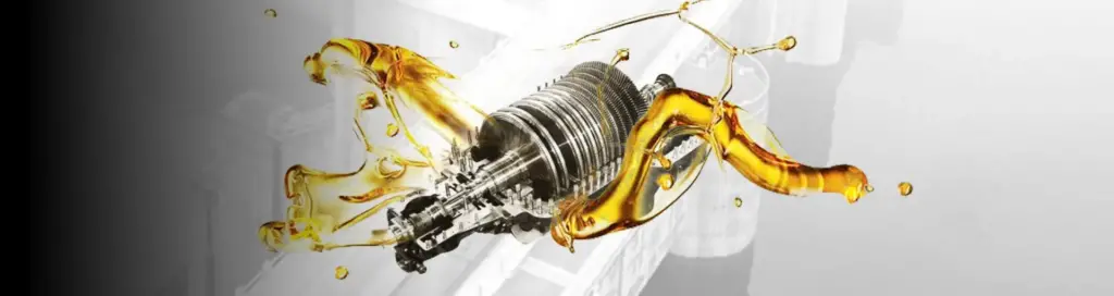a metallic mechanical component, possibly an engine part or a gear mechanism, with golden automotive lubricant fluid flowing around it.